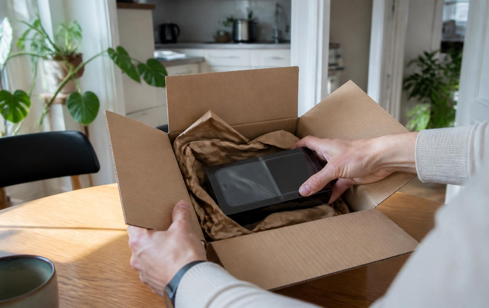 Neues verpacktes Smartphone in einem geöffneten Versandpaket